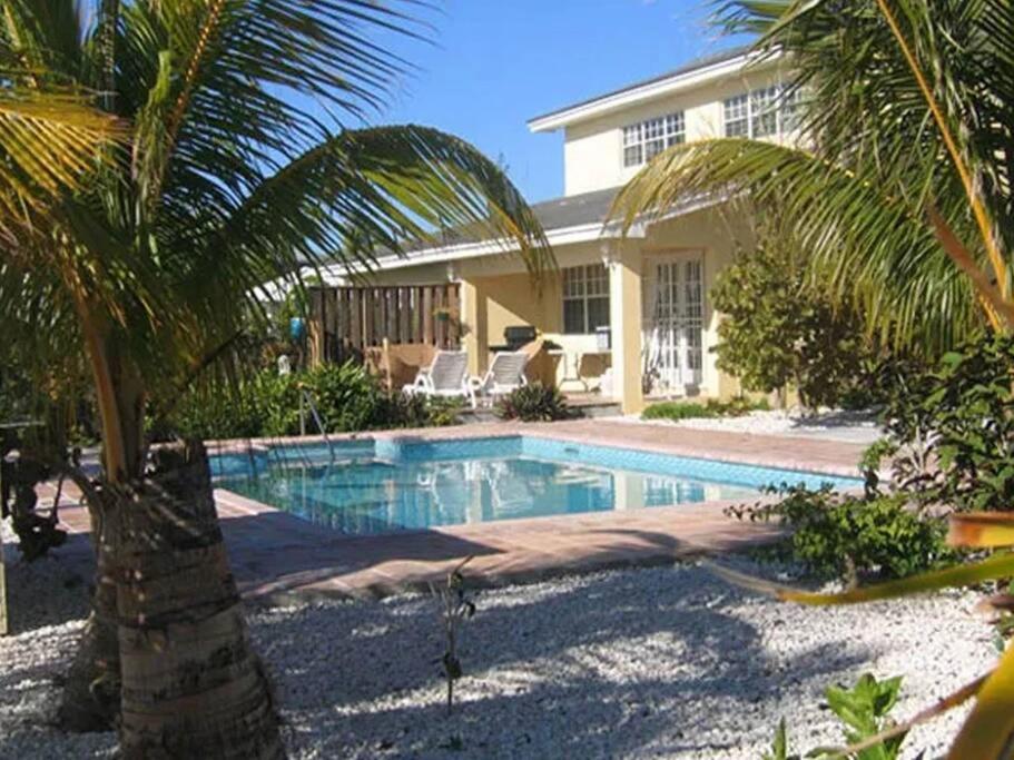 a swimming pool in front of a house at Beach Paradise with Pool and Boating Dock in Freeport