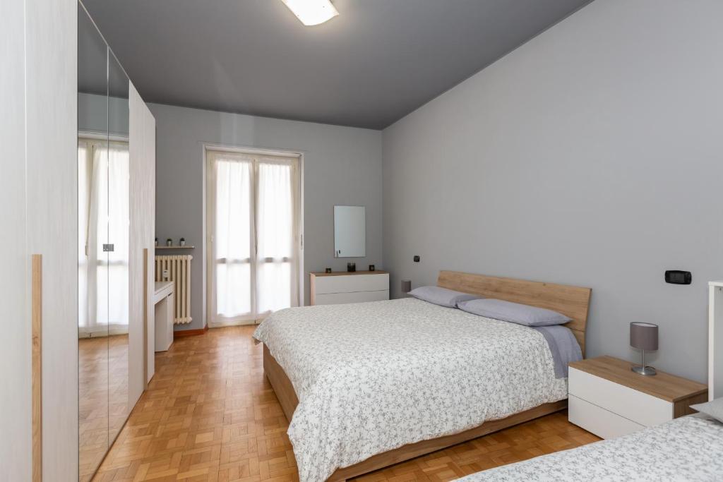 um quarto branco com 2 camas e 2 janelas em Interno Nizza em Turim