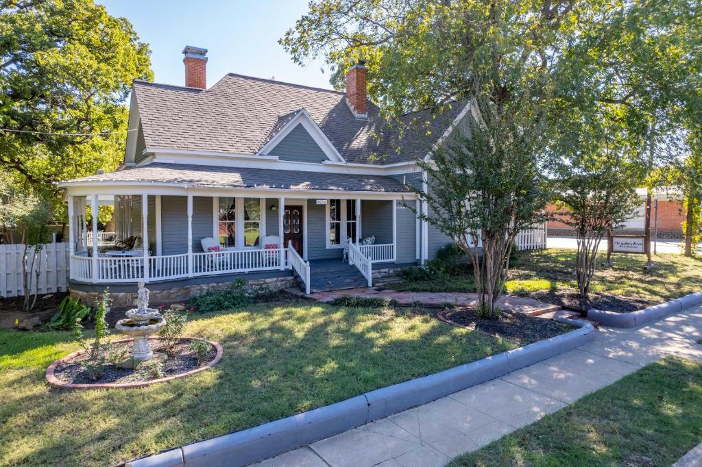 a house with a porch and a yard at The Gallery House Boutique Hotel in Stephenville