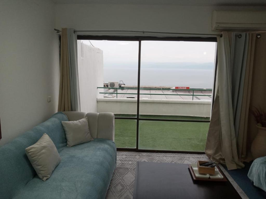 a living room with a couch and a large window at נוף הכנרת in Tiberias