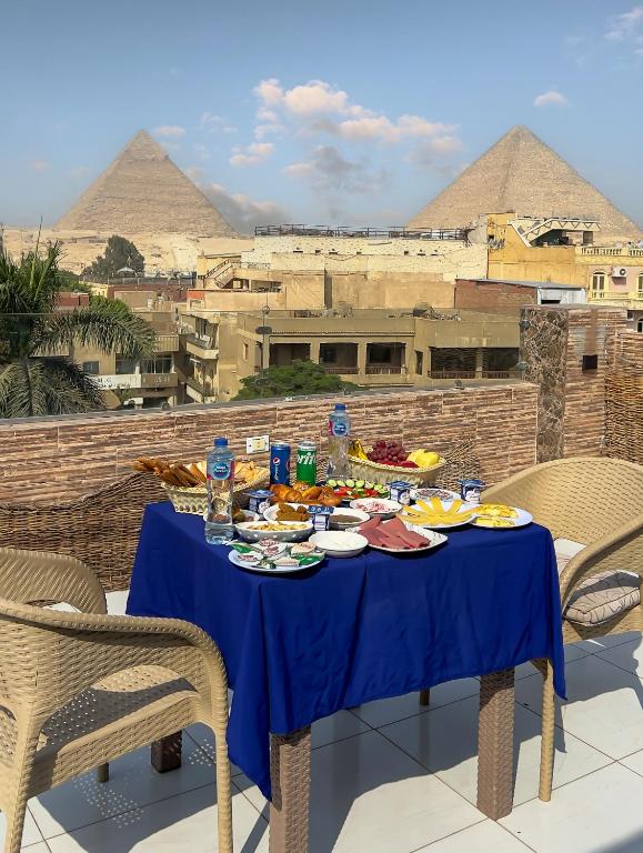 una tavola con cibo sopra con piramidi sullo sfondo di Makadi Pyramids View a Il Cairo