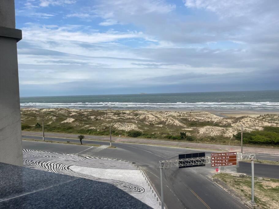 uma estrada com vista para a praia e para o oceano em Vista para o Mar em Laguna