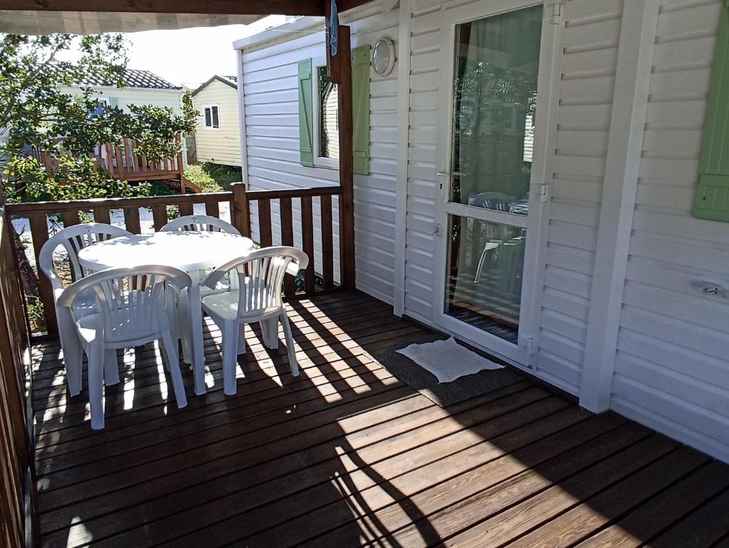 a patio with a table and chairs on a deck at Bungalow privado Tilda - na Landshouse in Burinhosa