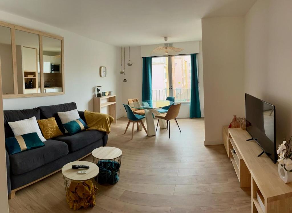un salon avec un canapé et une table dans l'établissement Joli appart proche plage du môle et flânerie, au Cap d'Agde