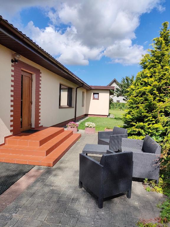 eine Terrasse mit Stühlen und ein Holzdeck in der Unterkunft U Derca in Gnieżdżewo