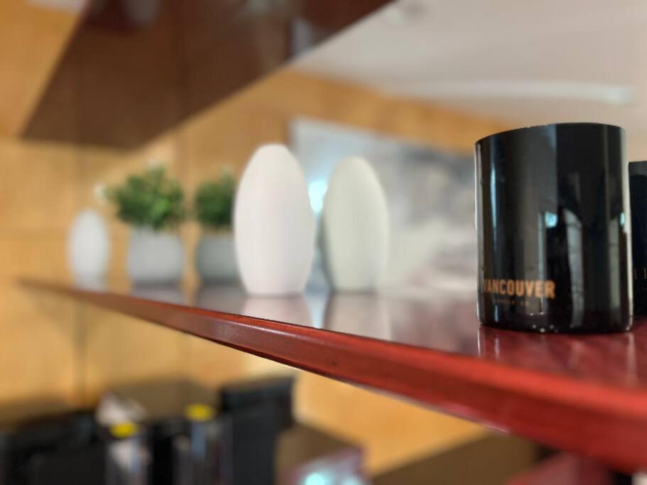 a black coffee cup sitting on a wooden shelf at Chic 2BR Suite in Vancouver West~UBC & Downtown in Vancouver