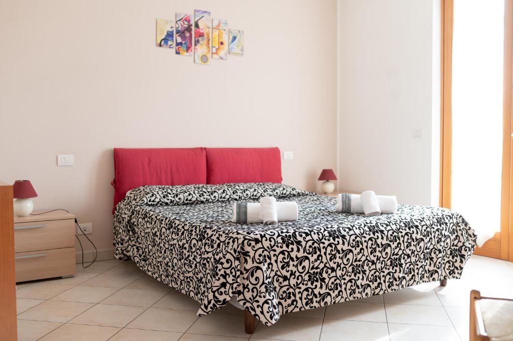 a bedroom with a large bed with a black and white blanket at Terrazza baciata dal sole in Lazise