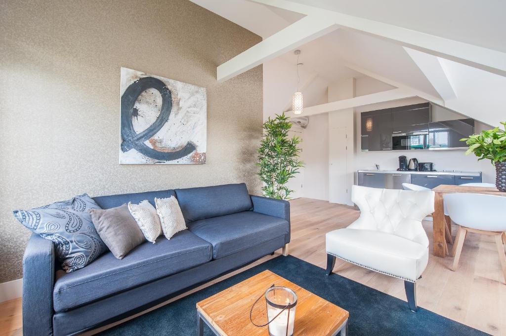 a living room with a blue couch and a table at Museumpark Apartments in Rotterdam