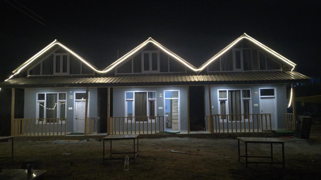 a house with lights on the front at night at MOKSHA COTTAGES AND WOODHOUSE in Kasol