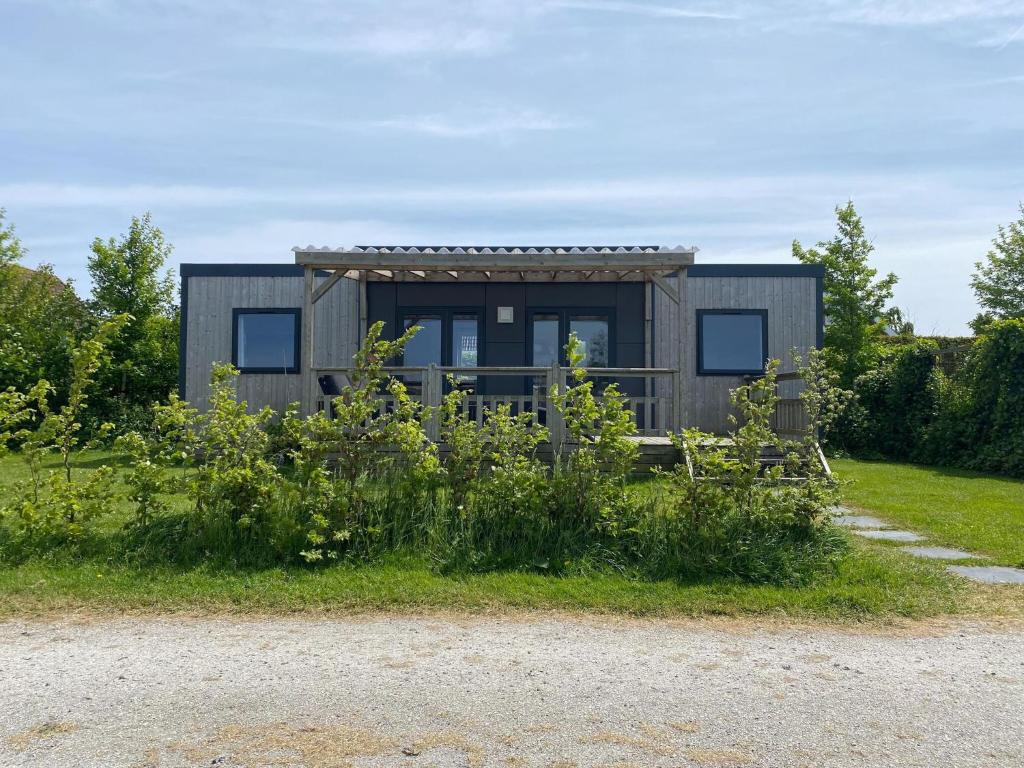a tiny house on the side of a field at Chalet in Friesland near Nature Reserves in De Veenhoop