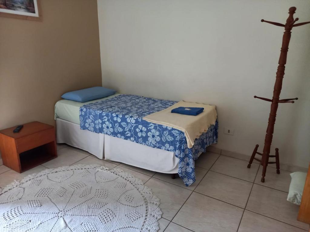 een kleine slaapkamer met 2 bedden en een tapijt bij Espaço Verona apartamento econômico c/banheiro e sem café p/ 1 pessoa in Fazenda Rio Grande