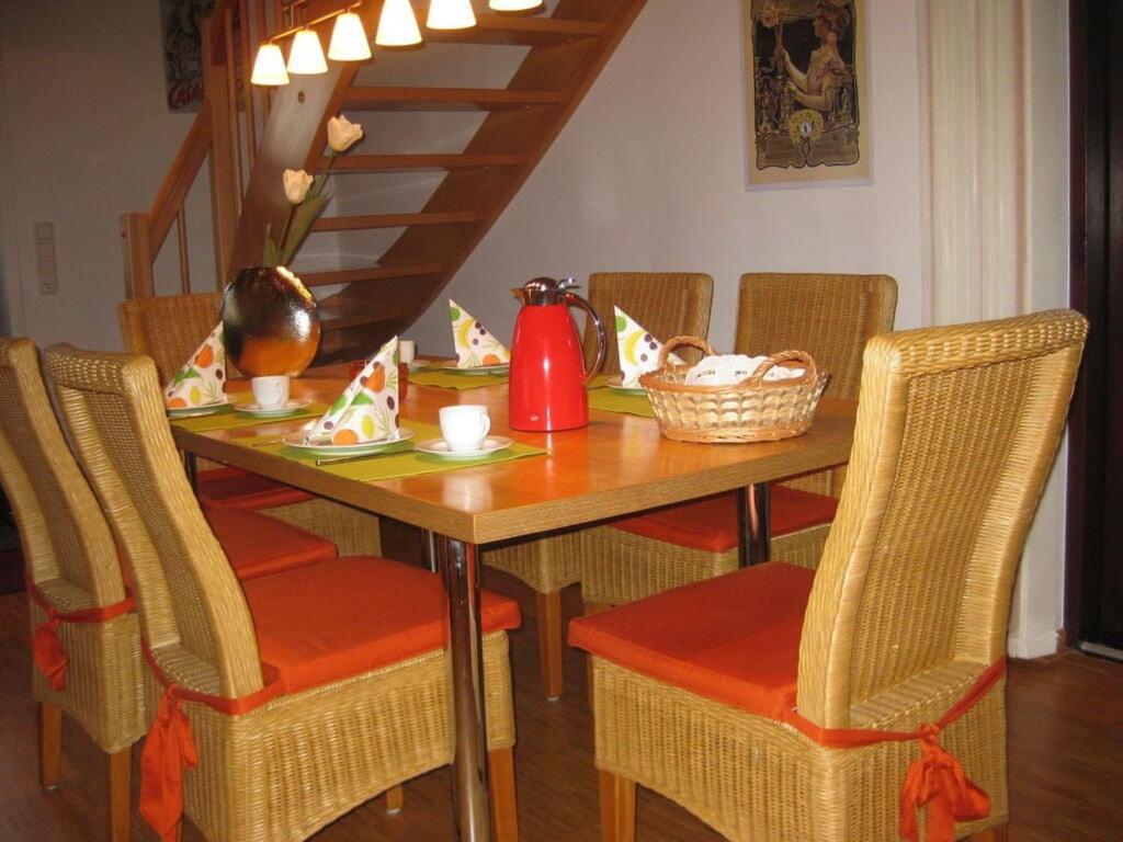 einen Esstisch mit Stühlen und einen Tisch mit einem Tisch in der Unterkunft Holiday home Haus Mewa in Neuenkirchen