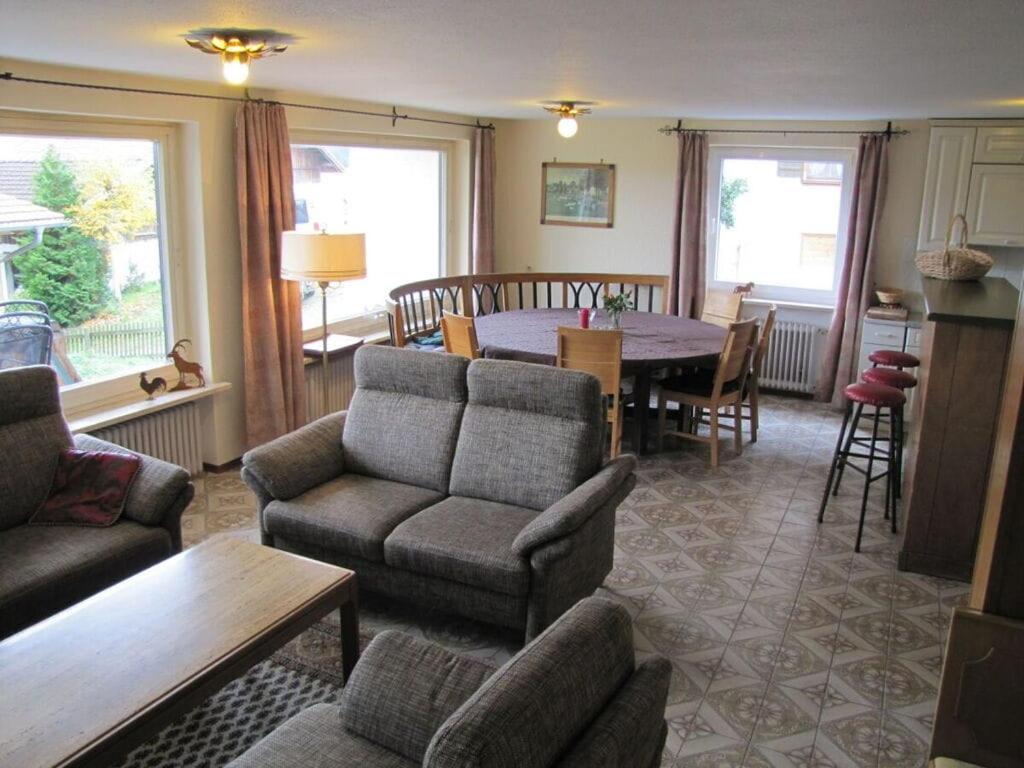 a living room with a couch and a table and chairs at Holiday home Eckstein in Oy-Mittelberg