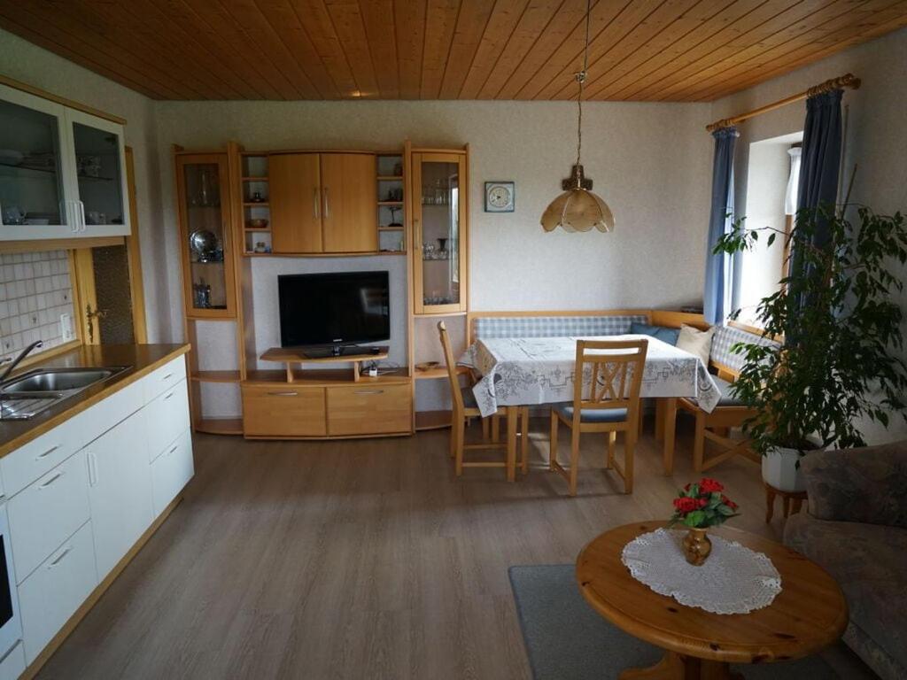a kitchen and living room with a table and a television at Holiday apartment Hildegard birds in Oberreute