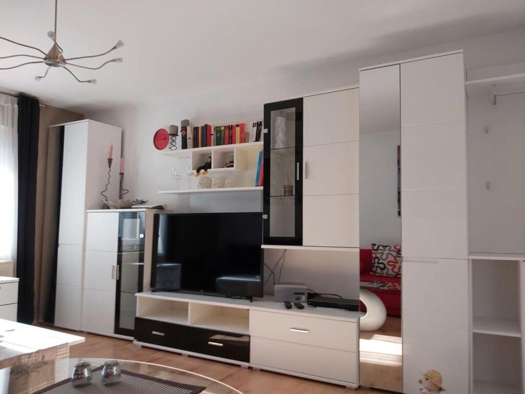 a living room with a tv and white cabinets at Idyll near Limburg Lahn in Hünfelden