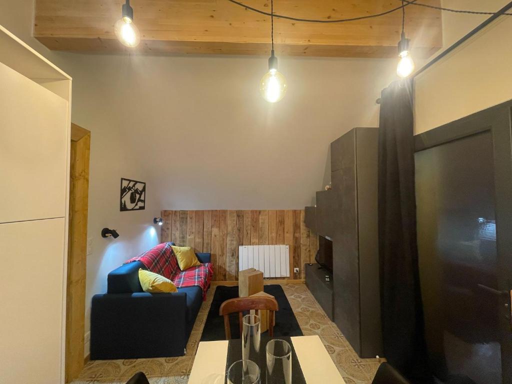 - un salon avec un canapé et une télévision dans l'établissement REFUGE DU CAP, à Saint-Lary-Soulan