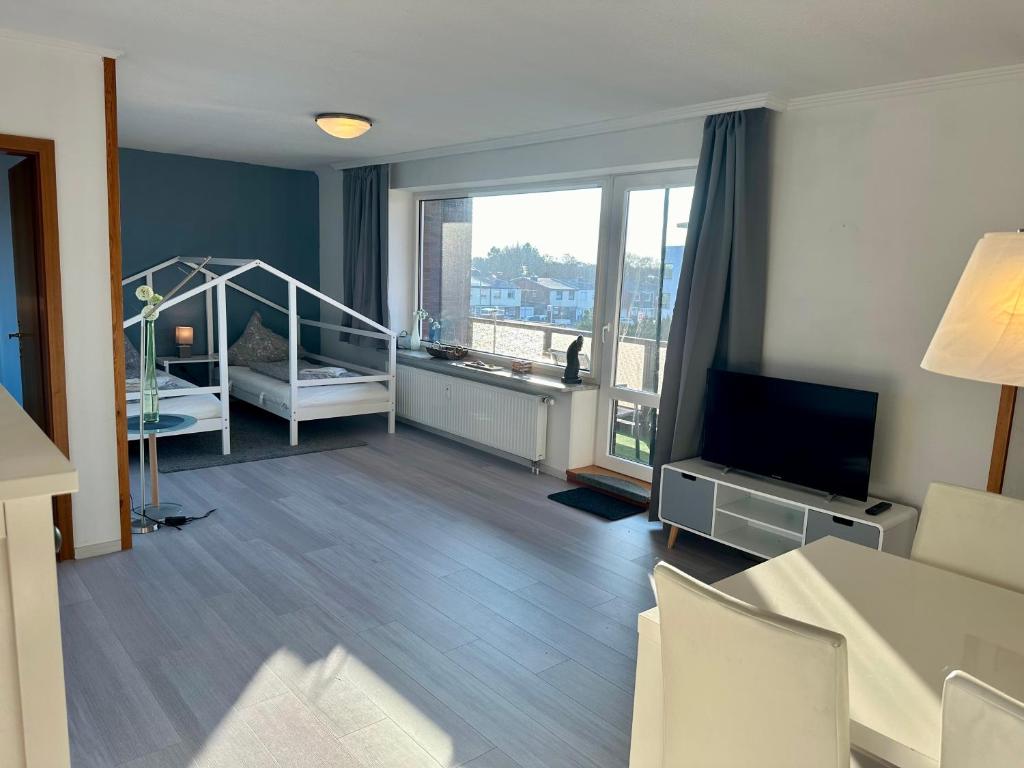 una sala de estar con una habitación con cama y TV en Haus Elbe Wohnung #15 - 10 min zu Fuß zum Strand, en Cuxhaven