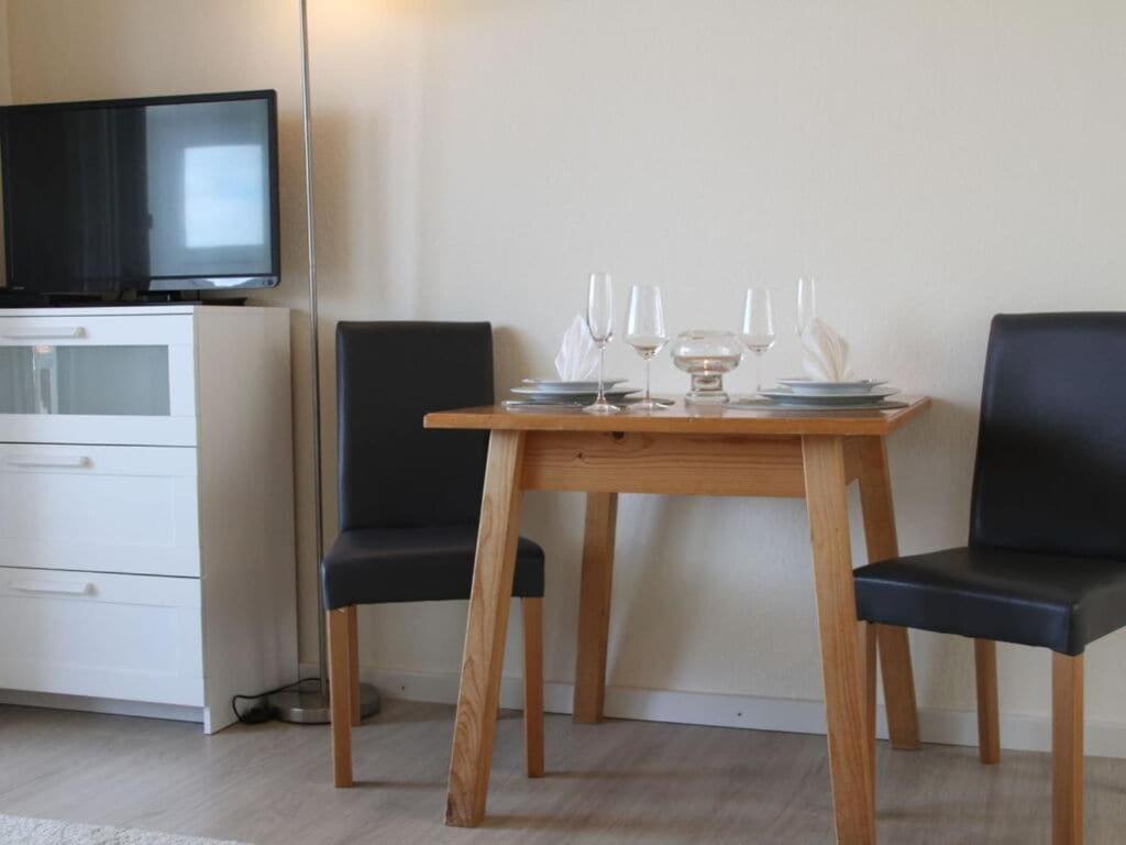 drewniany stół z 2 krzesłami i telewizor w obiekcie Landhaus Säntisweg - "Hochgrat" w mieście Oberreute