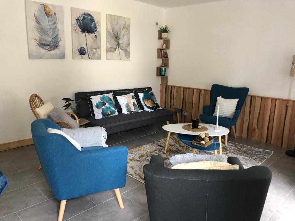 sala de estar con 2 sillas y sofá en Maison de caractère proche centre ville et termes, en Bourbonne-les-Bains