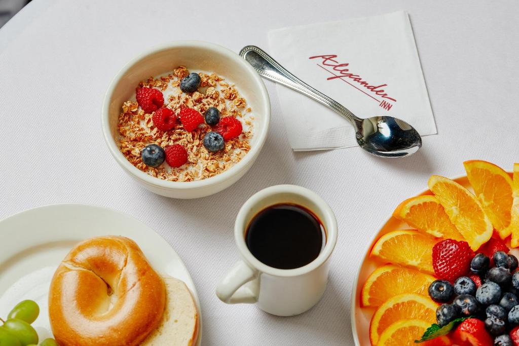 stół śniadaniowy z miską płatków zbożowych, filiżanką kawy i owocami w obiekcie Alexander Inn w Filadelfii