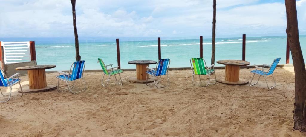 een groep stoelen en tafels op het strand bij Casa Praia de Tabatinga in Nísia Floresta