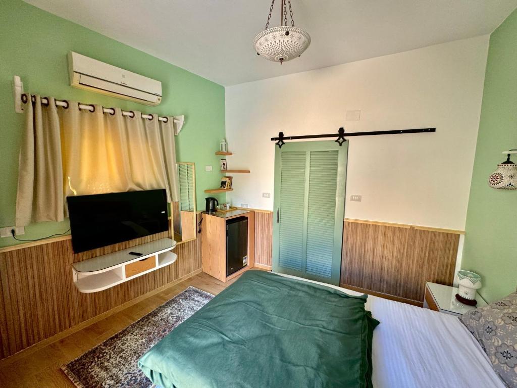 a bedroom with a bed and a flat screen tv at Beit Reihana in Dahab