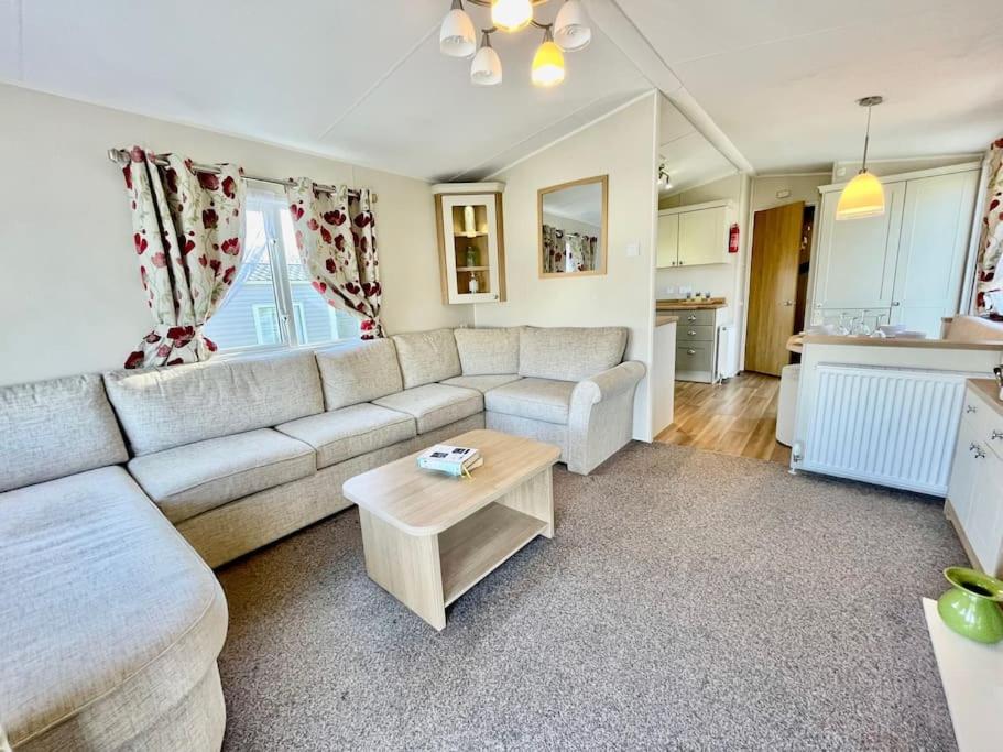 uma sala de estar com um sofá e uma mesa em Idyllic mobile home in beautiful surroundings em Porchfield