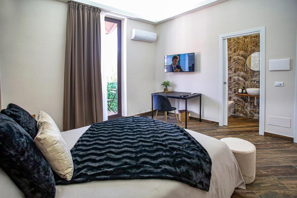 a bedroom with a bed and a desk and a window at Lustru Apartment in Catania
