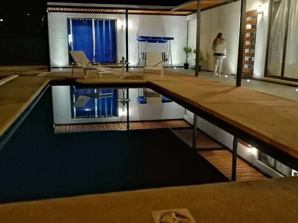 a person standing in a room with a swimming pool at WANNAQUEROS SUITES in Guanaqueros