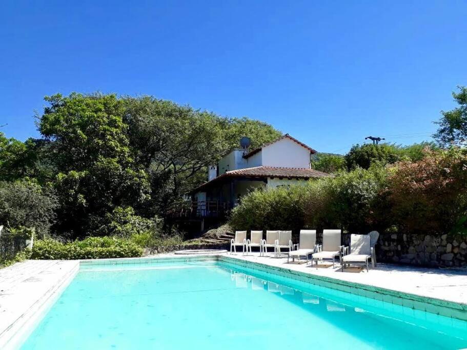een zwembad met stoelen en een huis bij Las Barrancas in San Lorenzo