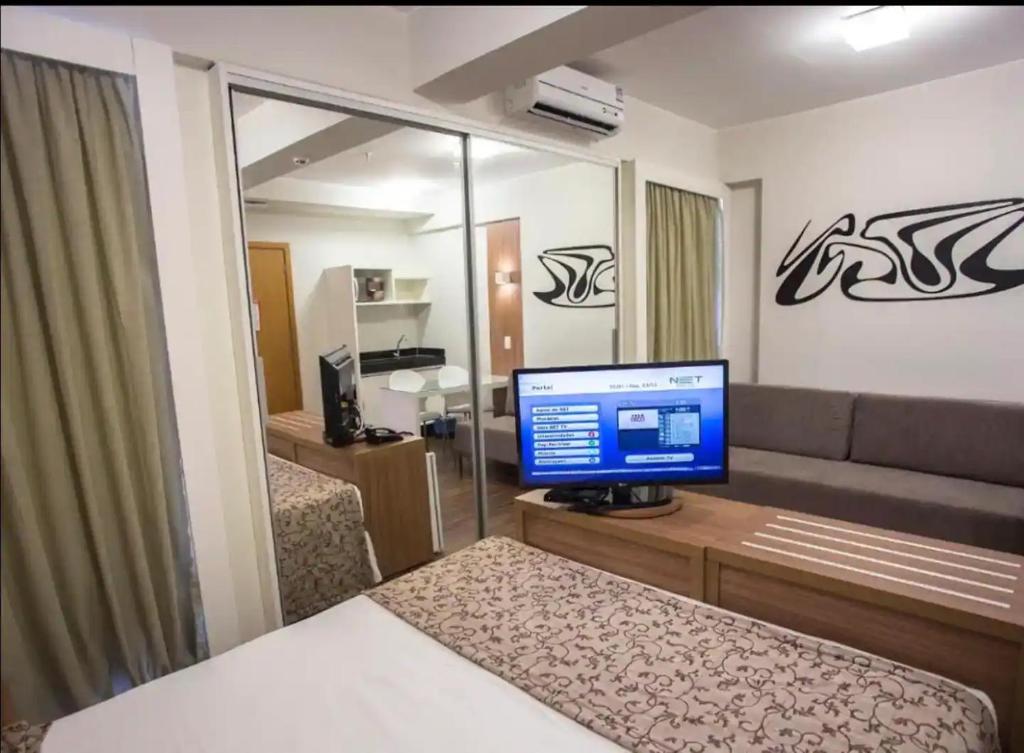 a bedroom with a computer monitor on a desk at S4 HOTEL: Flat Lindo, Aconhegante e bem localizado in Brasilia