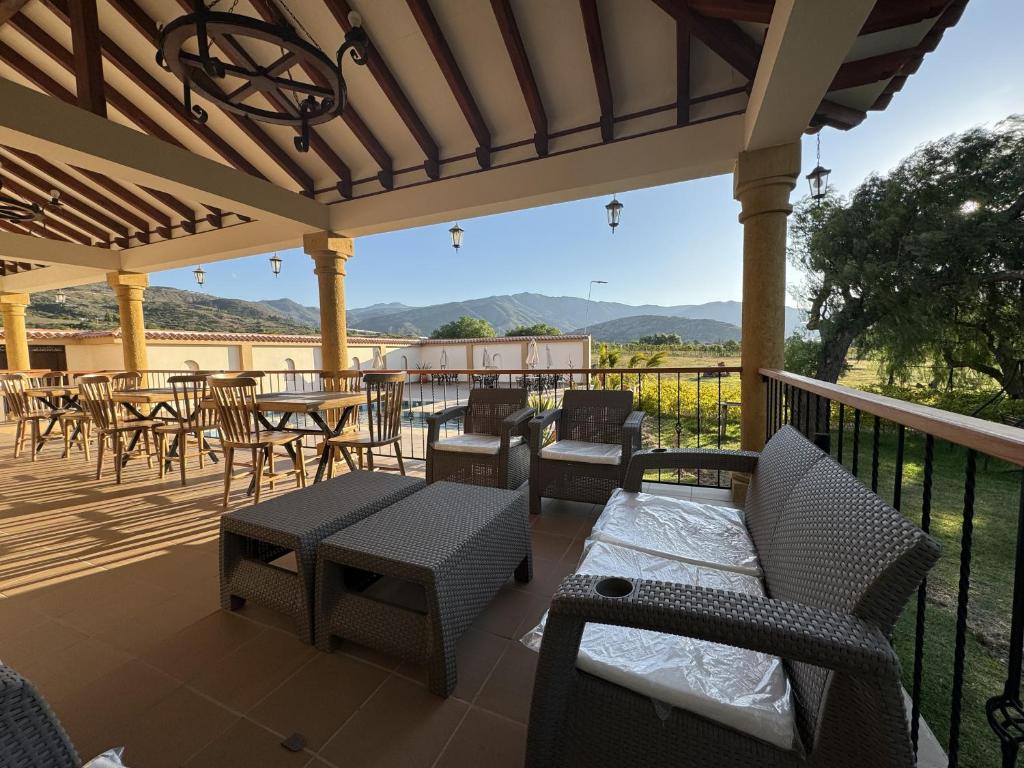 un patio con mesas y sillas y vistas a las montañas en Cádiz Hotel Boutique en Villa de Leyva