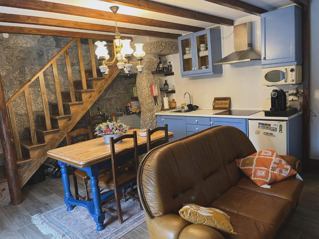 eine Küche und ein Esszimmer mit einem Tisch und einem Sofa in der Unterkunft Casa Pinhão in Sabugueiro