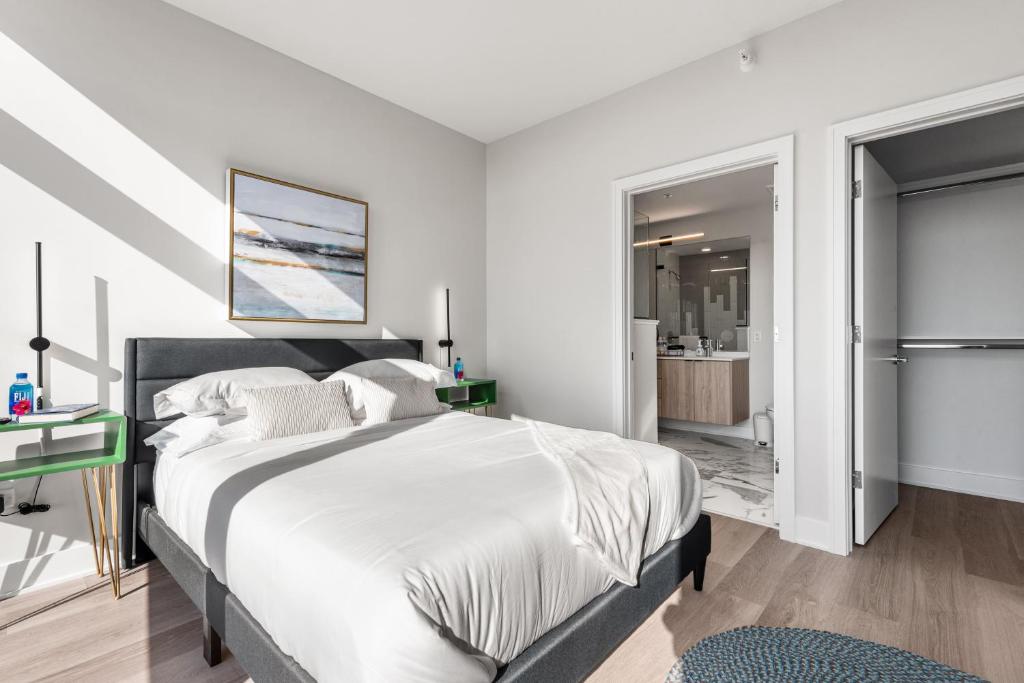a white bedroom with a large bed and a bathroom at Avra Stylish Apartments Prime West Loop Location Near Union Park in Chicago