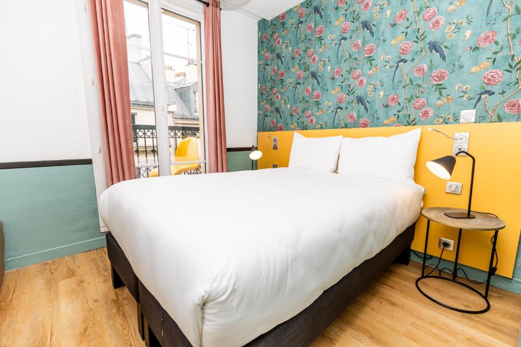 um quarto com uma cama grande e papel de parede floral em Vintage Paris Gare du Nord by Hiphophostels em Paris