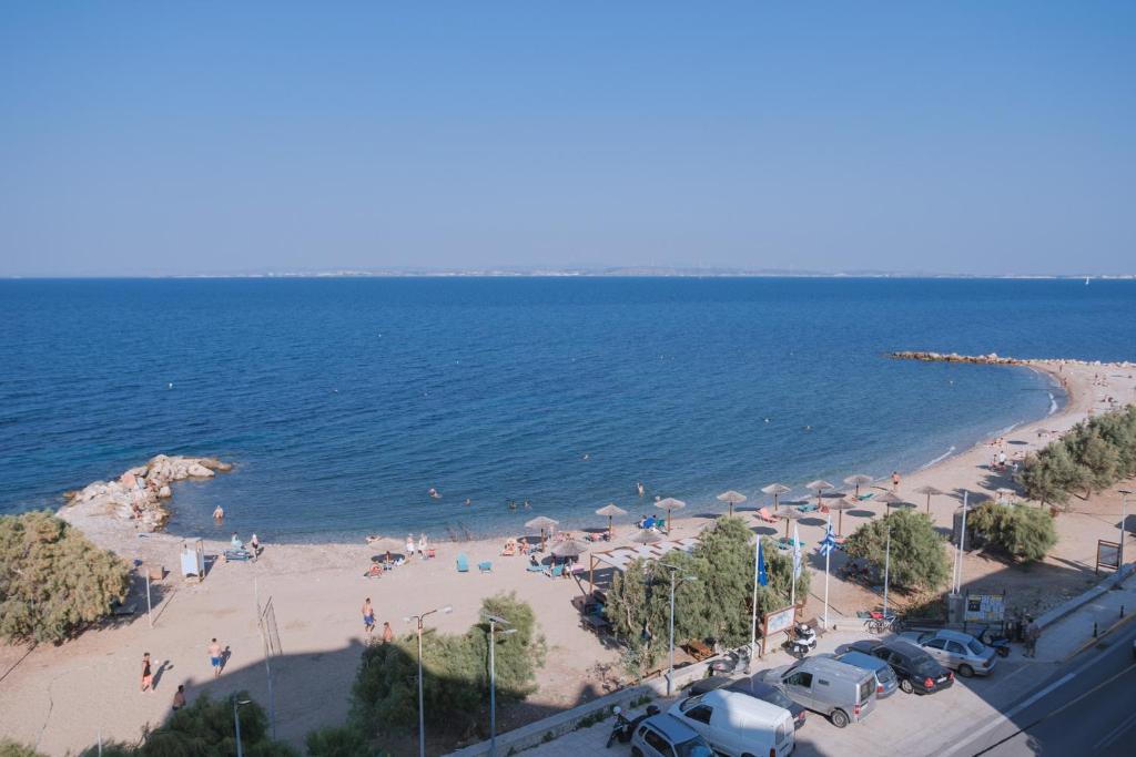 una playa con gente, sombrillas y agua en Bella vista studios en Chios