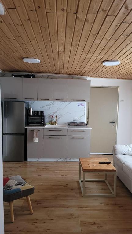een woonkamer met een tafel en een keuken bij Kasa lia in Herzelia 