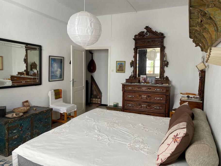 Schlafzimmer mit einem Bett, einer Kommode und einem Spiegel in der Unterkunft Chez Chichi in Sicca Veneria