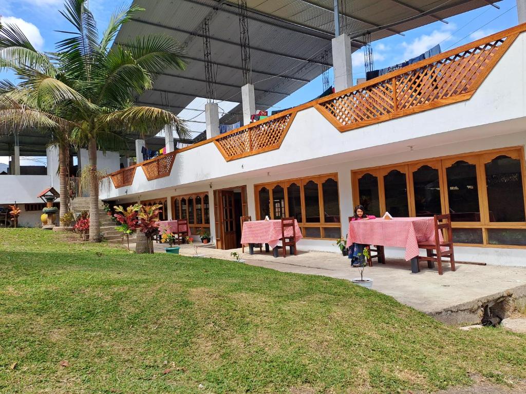a person sitting at a table outside of a building at La Ramada de Mama Elena in Oxapampa