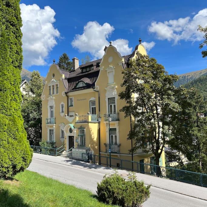 una grande casa gialla sul lato di una strada di Jugendstiljuwel in Bad Gastein a Bad Gastein
