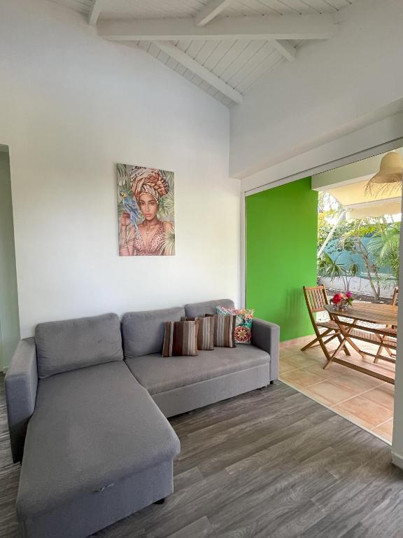a living room with a couch and a green wall at Résidence Subtropicale in Saint-François