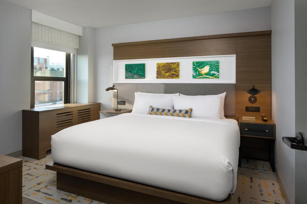 a bedroom with a large white bed and a window at Hotel Indigo Chattanooga - Downtown by IHG in Chattanooga