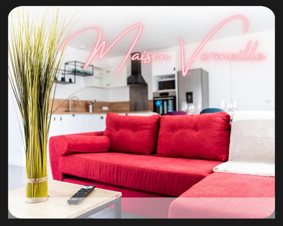 un sofá rojo en la sala de estar con un cartel en La Maison Vermeil - Grande maison moderne à Lavaur, en Lavaur