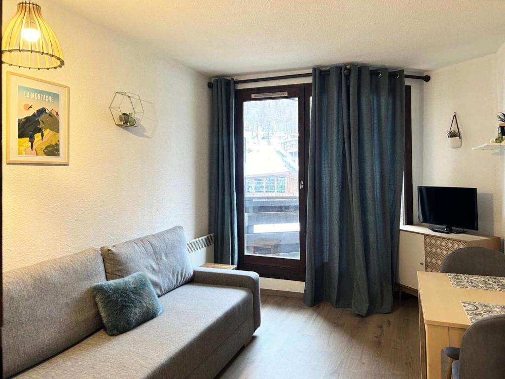 un salon avec un canapé et une fenêtre dans l'établissement Résidence Les Gradins - Grand studio pour 4 personnes MAE-0714, aux Orres
