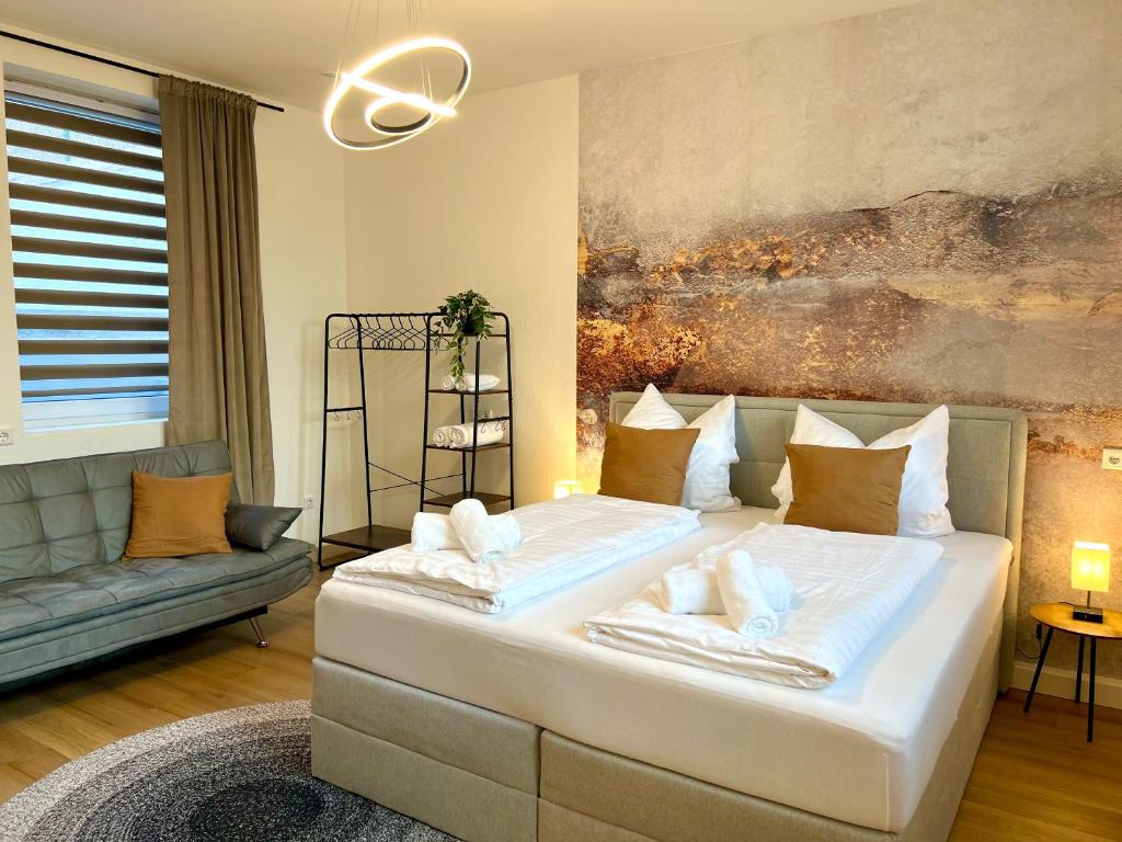 a bedroom with a large white bed and a couch at MAIN Cozy Casa am Ringpark Free Parking in Würzburg
