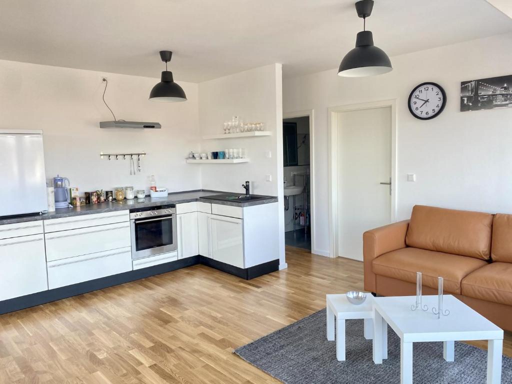 a kitchen and living room with a couch and a table at Living in a penthouse in Frankfurt, with balcony for smokers in Frankfurt/Main