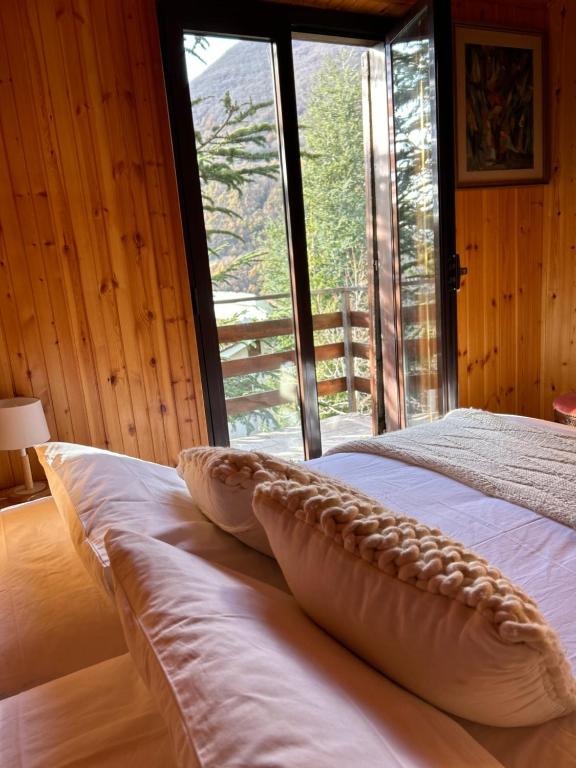 Cama con almohadas en habitación con ventana en Mansarda Val di Sangro, en Rocca Cinquemiglia