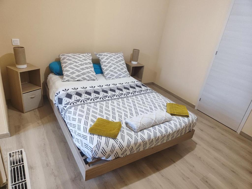 een slaapkamer met een bed met 2 kussens erop bij HOTEL DE LA GARE in Jussey