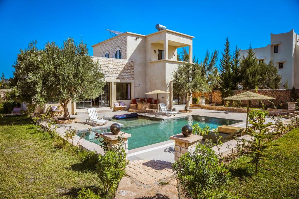 een groot huis met een zwembad in de achtertuin bij Villa OutMama charme & comfort in Essaouira