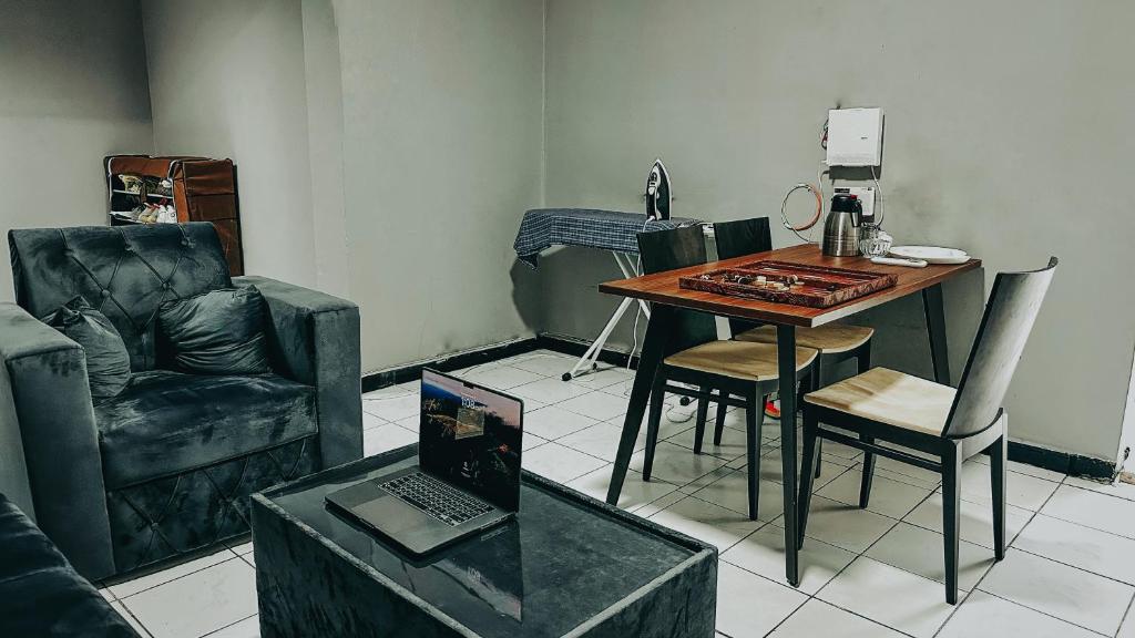 ein Wohnzimmer mit einem Tisch, Stühlen und einem Laptop in der Unterkunft Dubai Zeus Hostel in Dubai